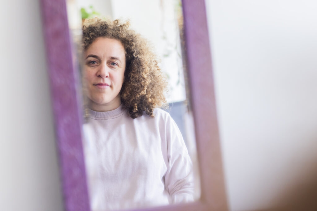 Vrouw kijkt naar haarzelf in de spiegel