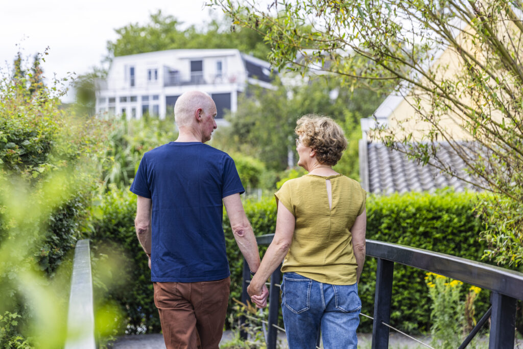 foto van man en vrouw die samen over een brug lopen.